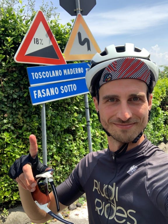 Rudi Rides staat bij fietsbord van 18 procent helling in Toscolano Gardameer