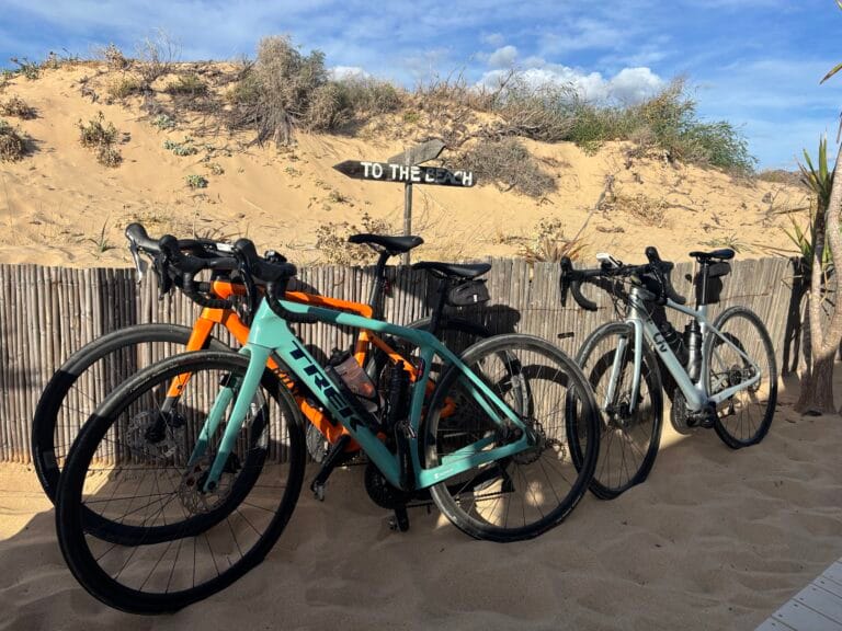 fietsen-geparkeerd-in-het-zand-strand-bij-portixeddu-sardinie Racefietsen op het strand bij Portixeddu op Sardinie bij Rudi Rides