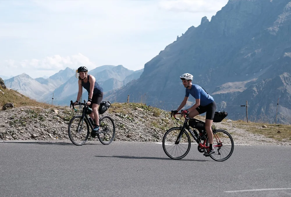 Twee fietsers man en vrouw met bepakking op Galibier in Franse Alpen