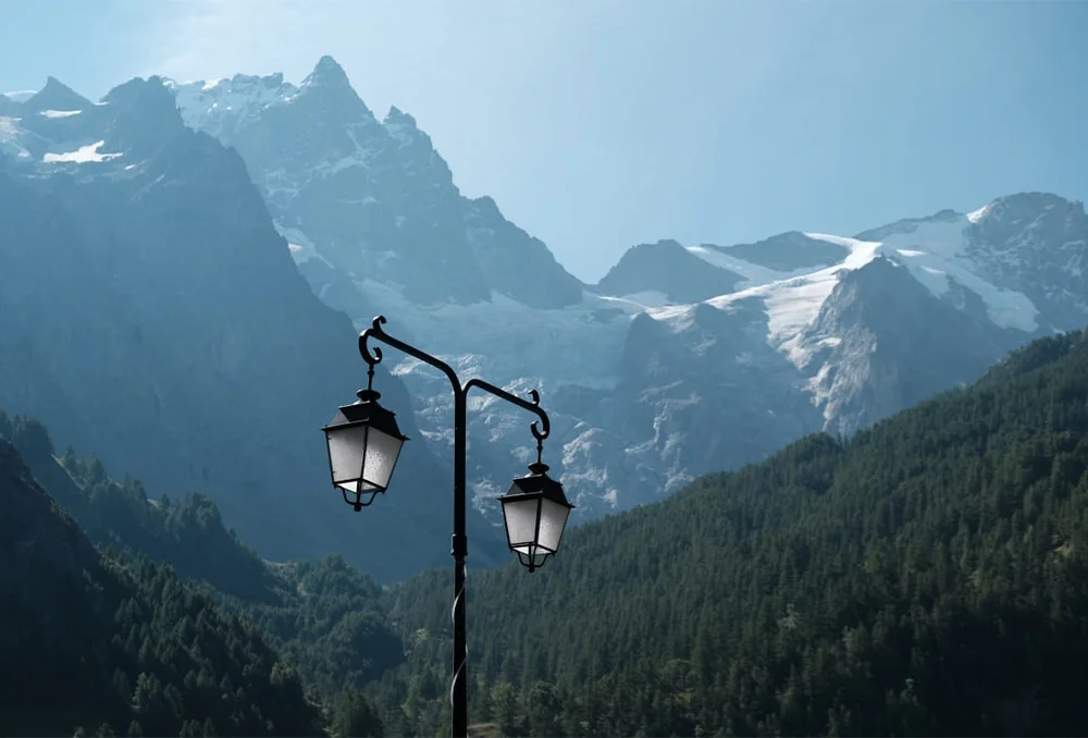 Gletsjers van La Meije met op voorgrond een lantaarnpaal in de Franse Alpen.