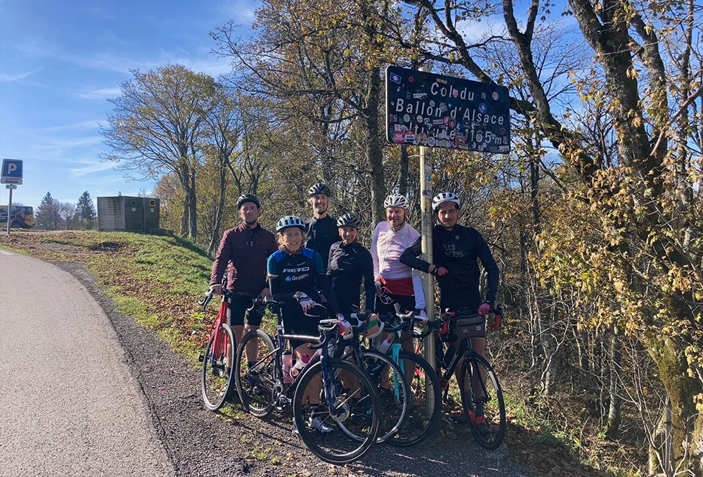 Een groep fietsers van Rudi Rides in de herfst bij het colbord van Ballon d'Alsace in de Vogezen