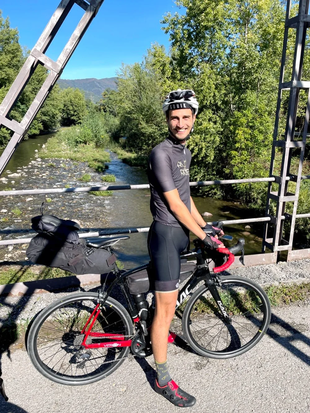 Rutger van Rudi Rides op een brug bij een rivier bij Brescia in Italië.