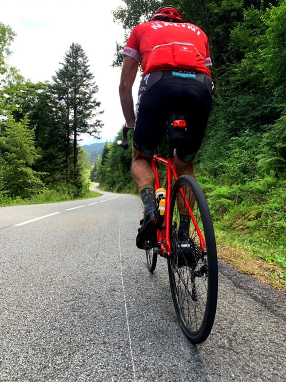 Fietser op rode racefiets in de Vogezen tijdens beklimming van Planche des belles filles