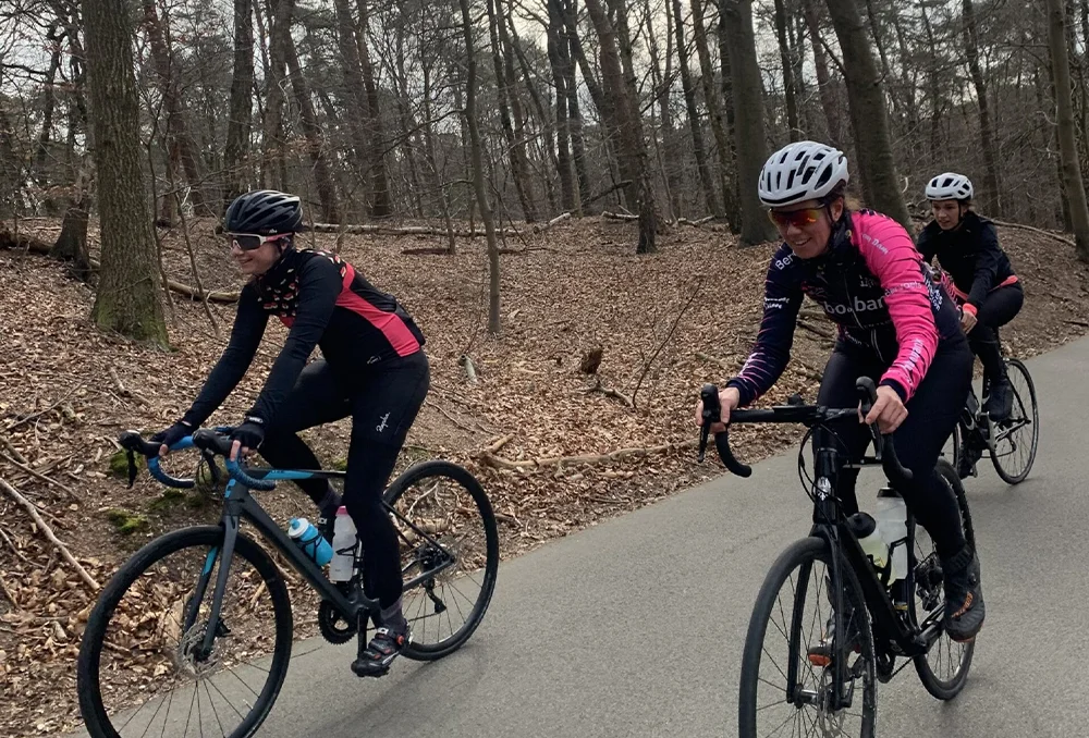 Fietsers in bos over asfaltweg in Gelderland in het voorjaar