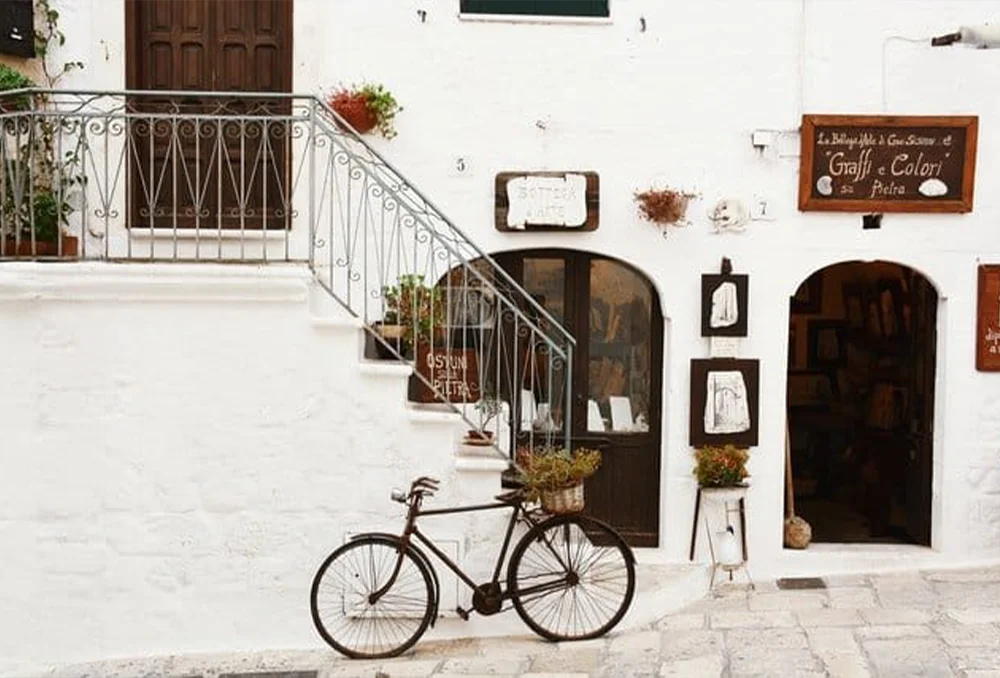 Oude fiets tegen witte muur in Zuid Italiaanse stad Ostuni