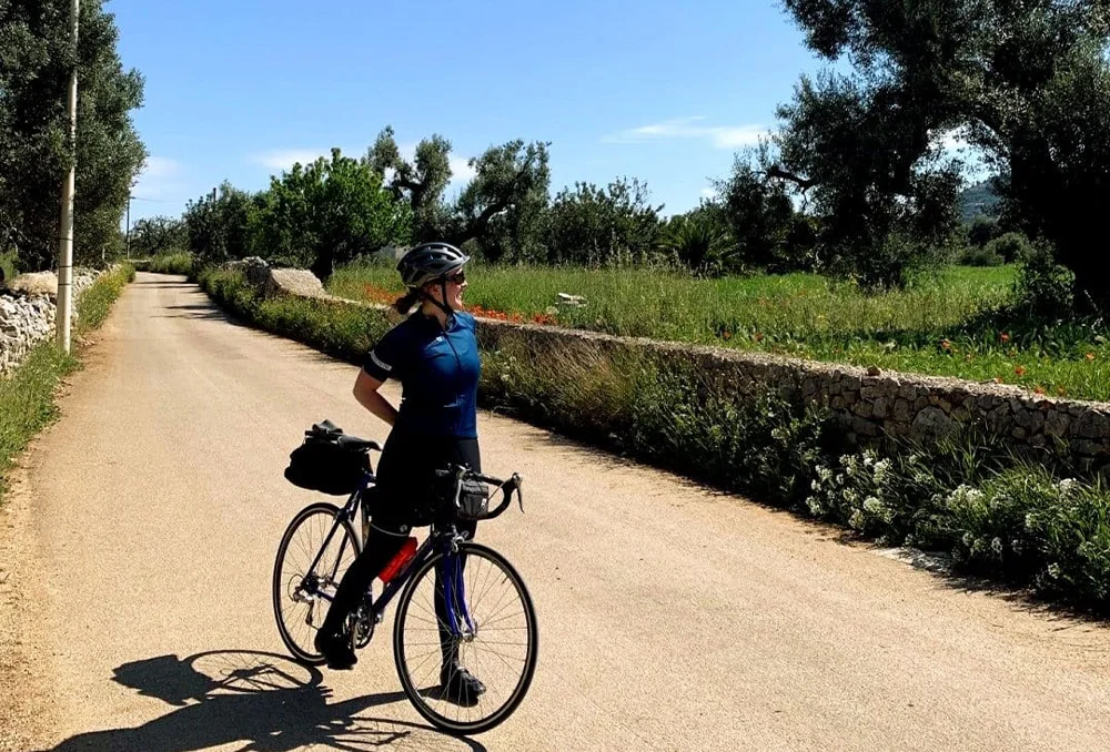 Fietser tussen de olijfbomen op de weg ergens in een afgelegen gebied van Puglia in Zuid-Italië