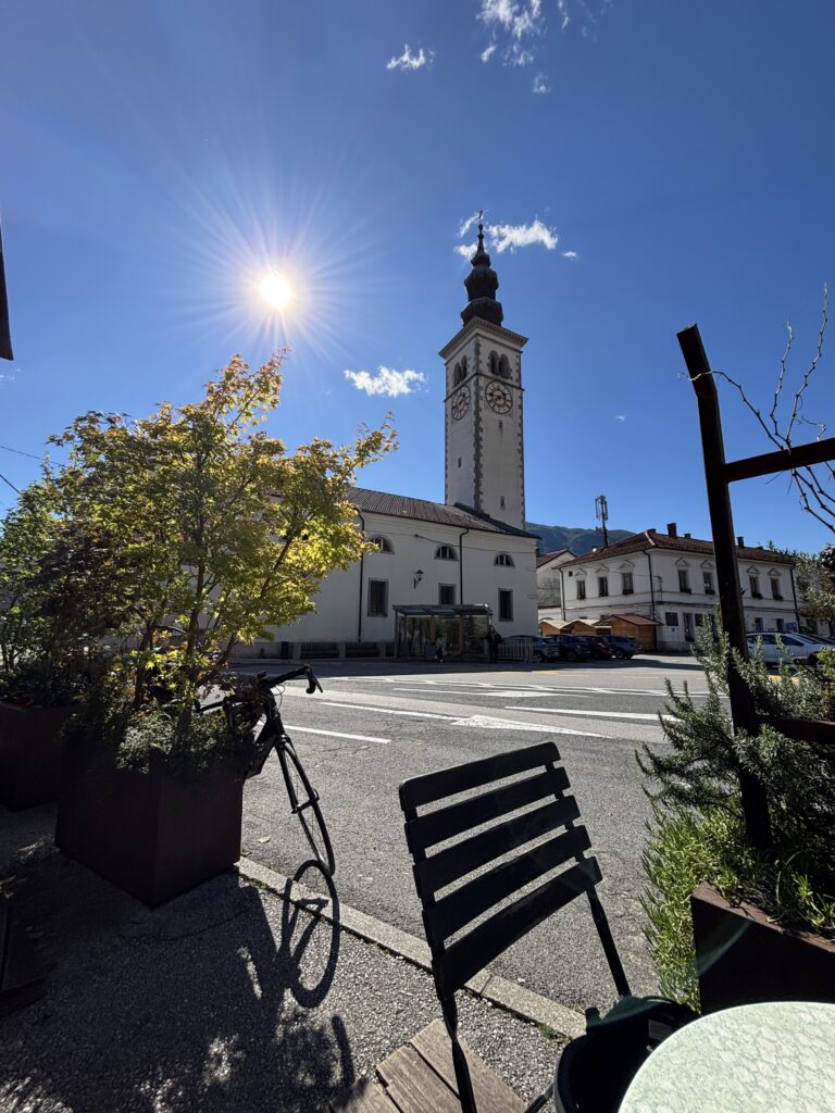 Kobarid stadscentrum met kerktoren vanaf een terras in de zon