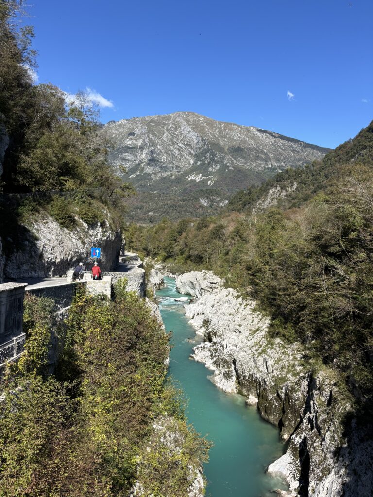 Smaragdgroene Rivier de Soca nabij Kobarid met fietsers bij uitkijkpunt